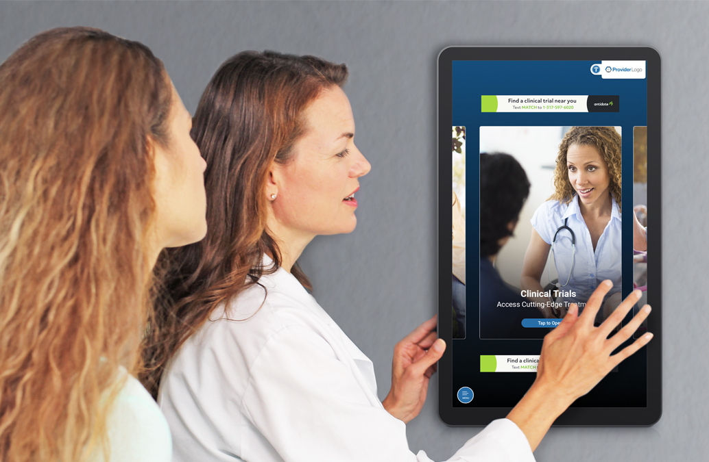 Woman doctor and woman patient interact with Antidote Association clinical trial education on a PatientPoint exam room touchscreen.